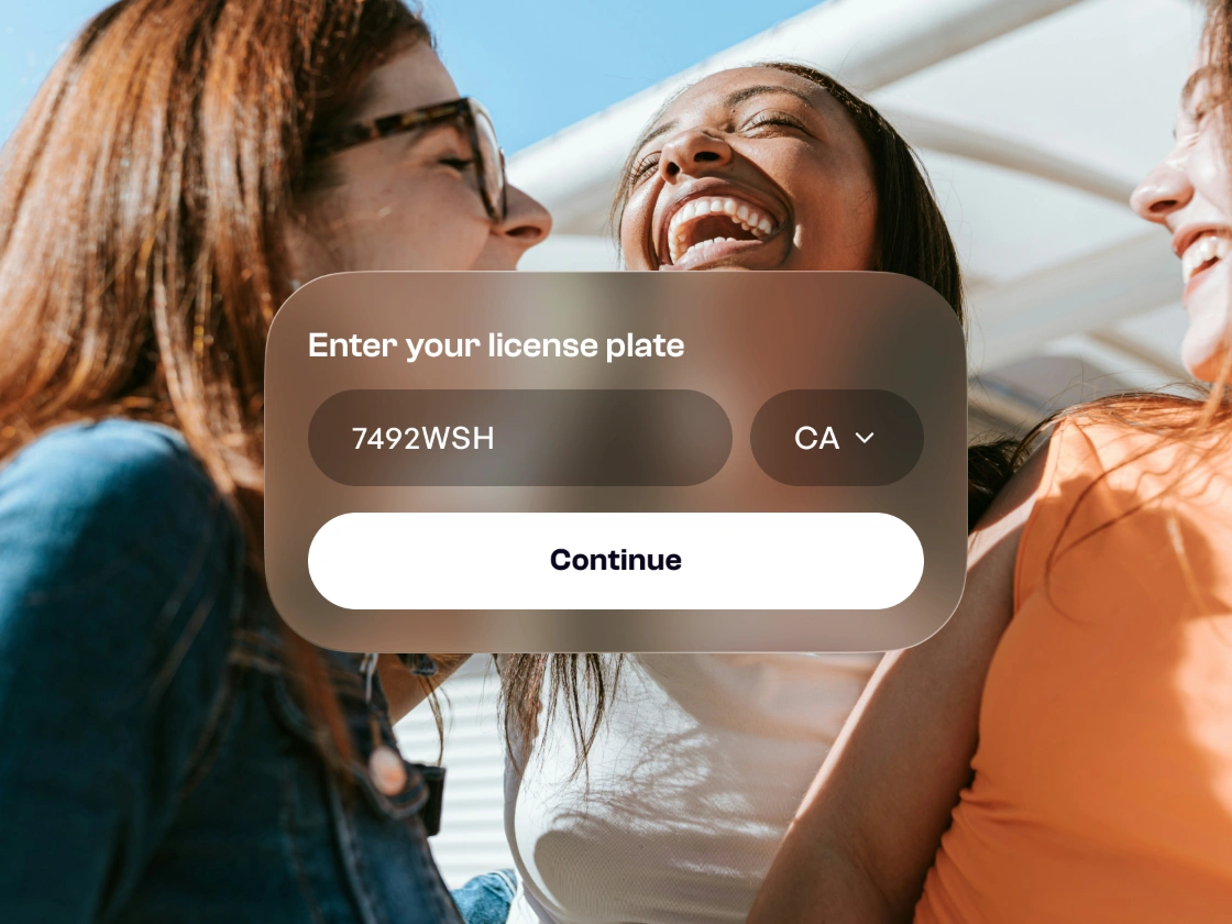 Friends laughing behind a license plate entry card