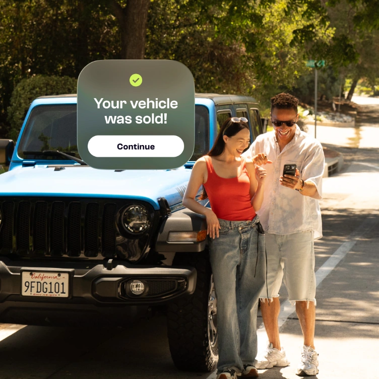 Couple celebrating next to their car after it sold